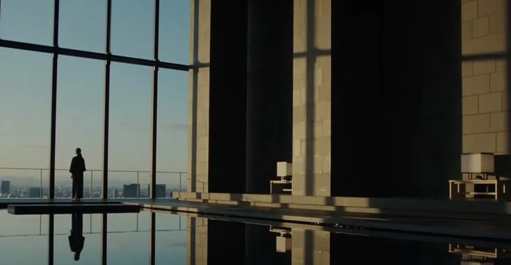 Sunlit high-rise interior overlooking the city, reflected in a pool